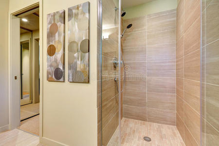 浴室淋浴，带玻璃门和天然彩色瓷砖。