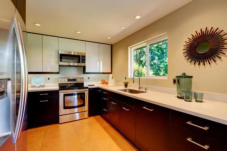 现代厨房配有白色的台面白色和棕色的新橱柜。