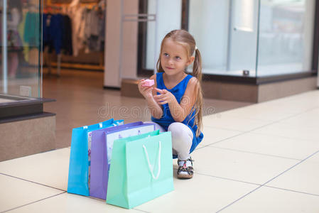 小时尚女孩坐在一个大包裹旁边图片