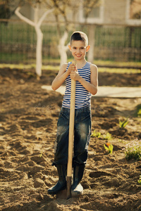 在花园里用铲子干活的小男孩
