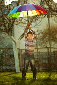 公园里拿着彩虹伞的小女孩