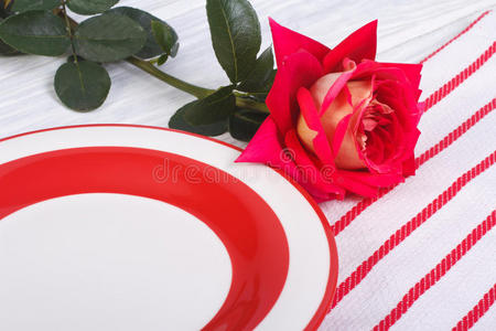 一朵红玫瑰和一个盘子。