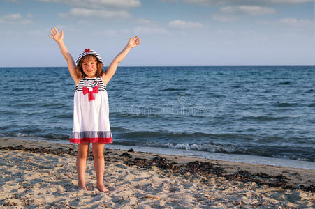 手举在沙滩上的小女孩图片