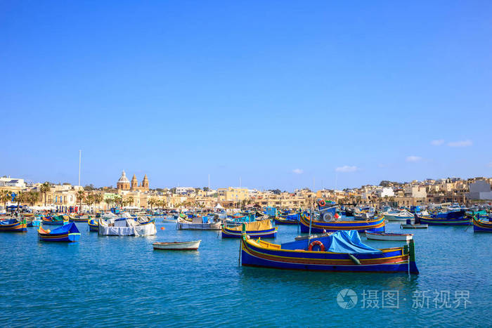 马耳他marsaxlokk的历史港口满载船只蓝天和村庄背景