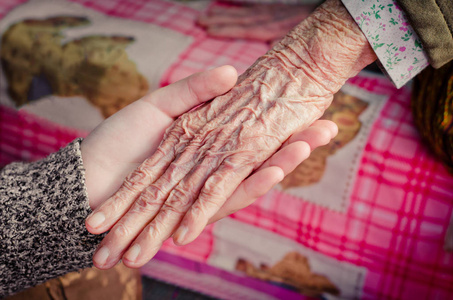 女孩的手抱着老女人展示你的爱和关心