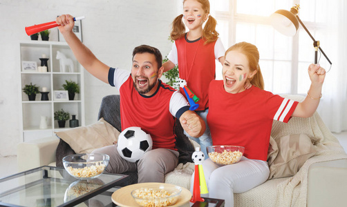 一个粉丝家庭在电视上看足球比赛家庭观看足球比赛在家里家庭观看足球