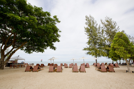 沙滩椅和雨伞在沙滩上。休息，relaxa 的概念