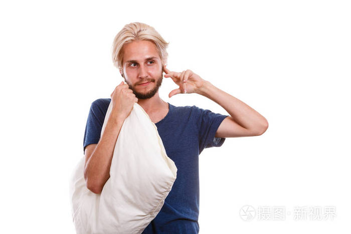 健康护理睡眠障碍的概念困累的家伙抱着枕头在一个和关闭他的耳朵另