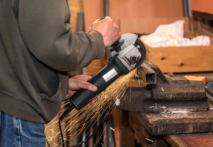 打磨火花人的工作与电磨工具钢照片