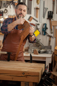 一匹木马是所有时间的玩具。木匠工作与一个刨床在车间为生产古董家具。他为孙子做木制马。
