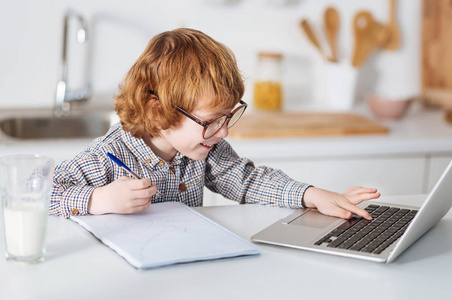 好奇的辉煌孩子用他的笔记本电脑