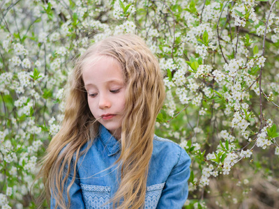 一个女孩在樱桃的肖像。女孩与她的头发在一个樱桃花花园牛仔衬衫