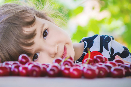 孩子在花园里摘樱桃。选择性的焦点