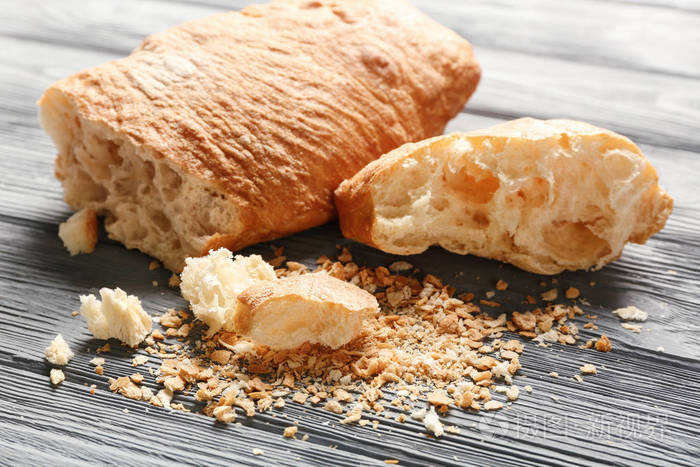 面包和木制的桌子上的面包屑照片-正版商用图片0p9wvu-摄图新视界