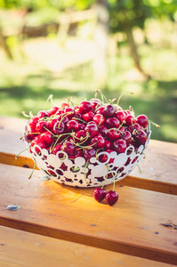 成熟的红樱桃水果在篮下的木桌上户外