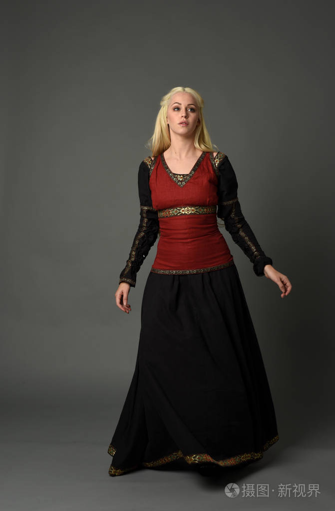 穿中世纪长袍的金发女郎的全长肖像, 站立姿势在灰色演播室背景