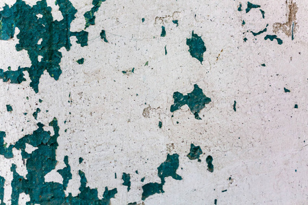 划伤的水泥墙上涂有陈旧的颜色参差不齐的石膏墙质地。旧漆墙背景
