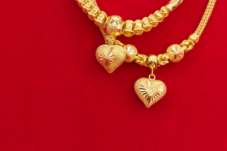 红色法兰绒背景的豪华金项链, 美丽的金牌是挂饰饰品亚洲风格