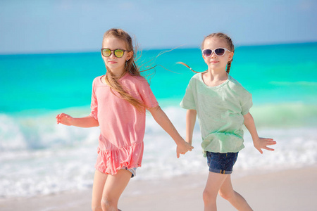 可爱的小女孩一起玩乐白色的热带海滩上