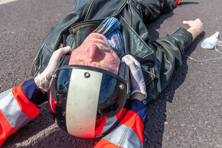 一名德国护理人员从受伤的骑车人身上取下头盔。Rettungsdienst 是德国的救护车服务词