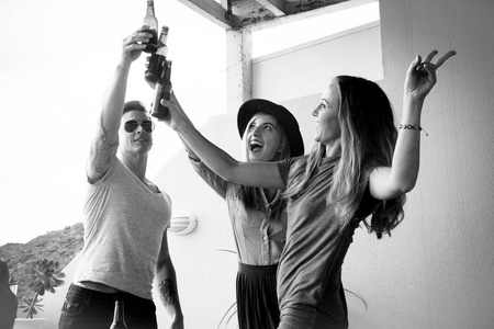 成功的团队合作喝啤酒的概念。一群美丽的人在阳台上开心的喝着啤酒瓶。呼喊, 微笑, 一起欢笑
