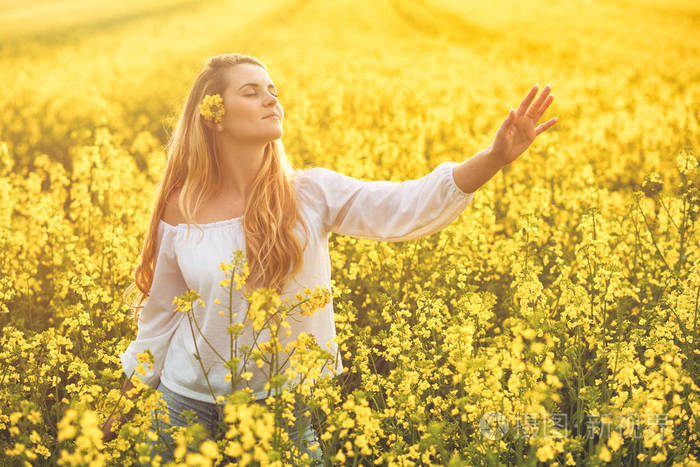 黄色的油菜田的女人的微笑着阳光灿烂的日子