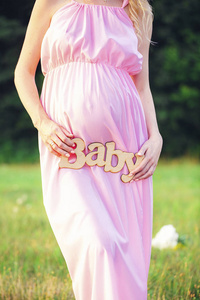 标签宝贝在户外一个怀孕的女人的手