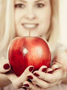 幸福的女人抱着美味的红苹果