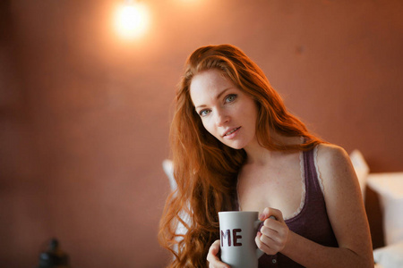 美丽的红头发女人喝咖啡