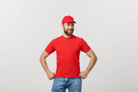 微笑送货员在红色制服站与手臂交叉孤立在白色背景