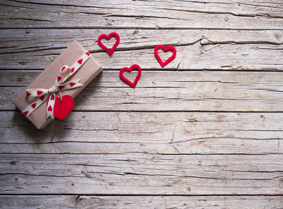 情人节礼品盒和红色的心形标记在木板上