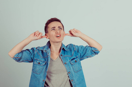 堵耳朵抬头的男孩一样的女人女孩的肖像照片