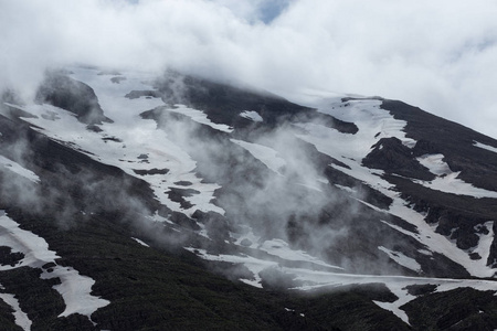 由融化的雪云覆盖的山坡