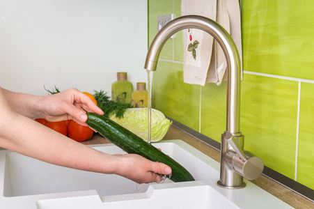 女人洗黄瓜沙拉新鲜蔬菜