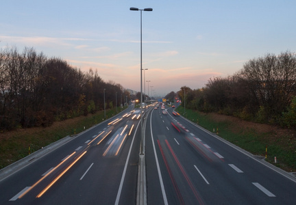 交通，光迹在日落时在公路上的汽车