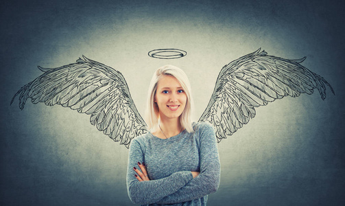 蓝眼睛和交叉的手想象自己作为一个天使在她背后的翅膀和一个光环