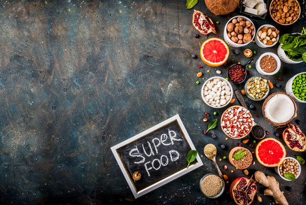 集有机健康饮食食品超级豆类豆类坚果种子蔬菜水果等。深蓝色背景复制空间顶部视图