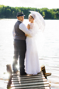 新郎和新娘站在一座桥附近的水