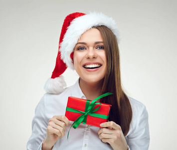 戴着红色礼盒的圣诞老人帽子上的微笑的女人肖像在白色背景下被隔离