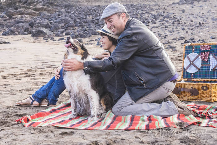 自由和休闲 pic nic 在海滩上的活动为一个替代家庭的朋友, 两个人和一只漂亮的狗。每个人都有乐趣户外度假