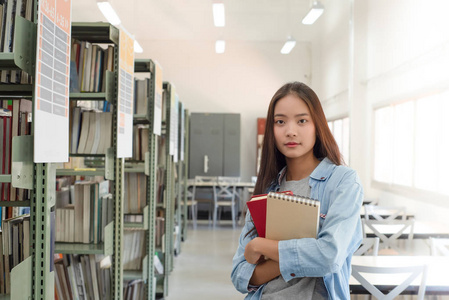 美丽的女性在大学图书馆读书和研究