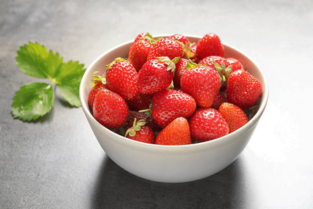 灰色背景的成熟草莓碗