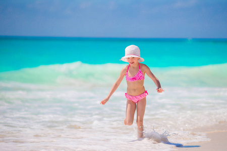 在海滩有很多乐趣在浅水里的可爱小女孩
