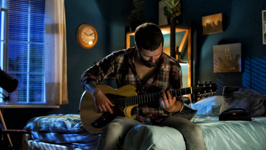 年轻人在晚上弹吉他