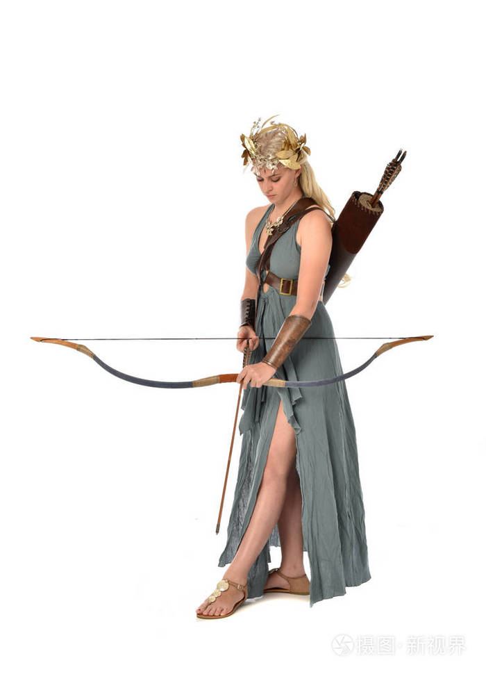 全长肖像漂亮的金发女郎穿着梦幻长袍, 并持有弓和箭.
