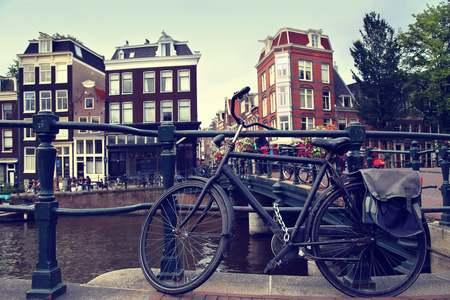 旧自行车停放在荷兰阿姆斯特丹运河旁