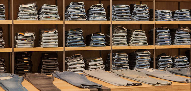 在商店货架上的牛仔裤裤。蓝色牛仔裤牛仔布收集牛仔裤堆积