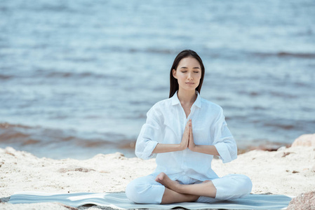 有吸引力的亚洲妇女沉思在安贾莉手印 称呼封印 在瑜伽垫上的海上姿势