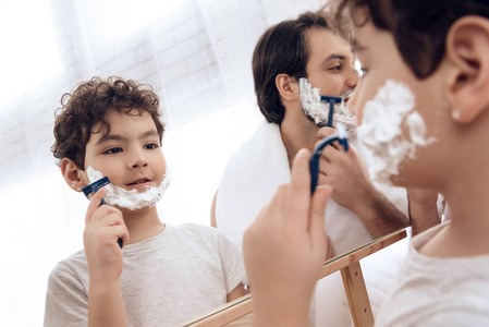 有胡子的父亲与小儿子在洗手间剃须