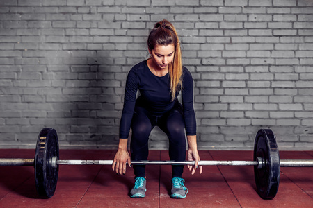 硬拉女运动员做硬拉在健身房照片